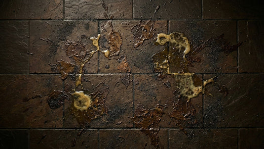 Dirty dark bathroom tiles covered in dried mud and grime stains before cleaning